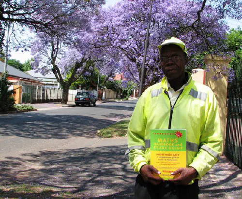 Simon, a Melville car guard, with a math book