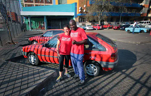 Heather with George in front of her stick-shift car