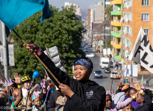 Girl waving a flag during the Hey Hillbrow Let's Dlala Parade