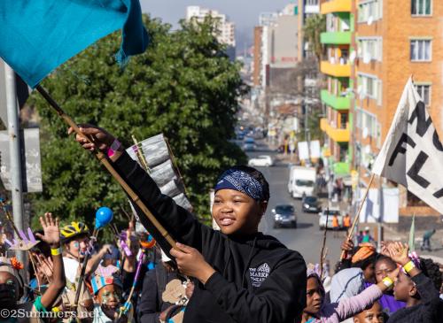 Girl waving a flag during the Hey Hillbrow Let's Dlala Parade